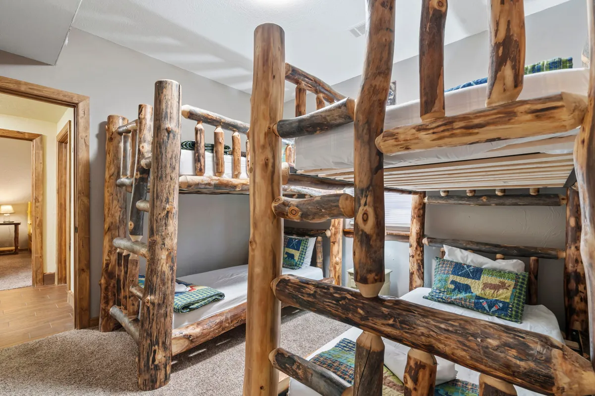 A lively, playful bunk room with textured wooden bunk beds and cheerful decorative pillows, inviting kids to enjoy sleepovers, storytelling, and creative playtime in a space designed just for them.
